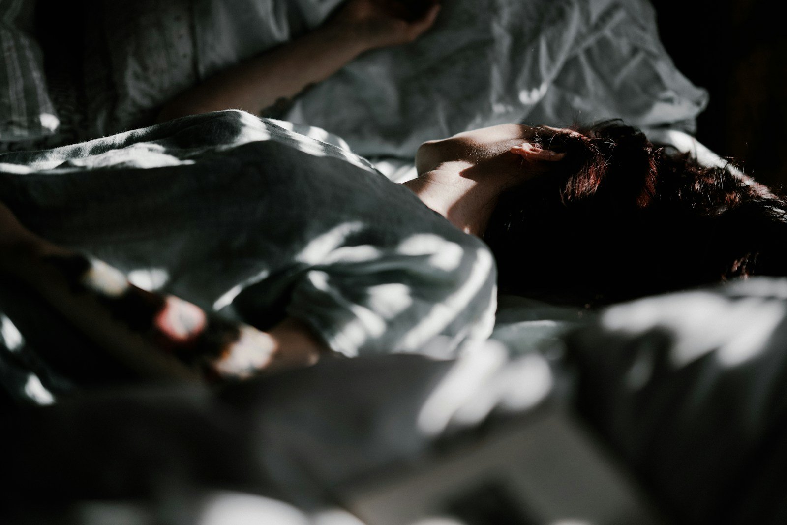 Donna che dorme serenamente nel letto: dormire meglio dopo il cambio ora solare